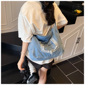 Mannequin portant un grand sac besace en jean délavé avec franges et poches