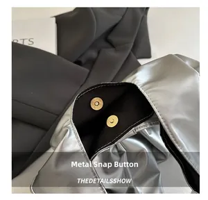 Detail of golden magnetic clasp closure on a metallic silver denim tote bag for women
