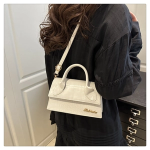 Chic white crocodile embossed crossbody bag with gold logo on a model's side view
