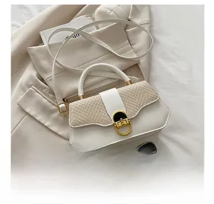 Detail showing white polygon box bag with woven flap and gold clasp on a beige blazer