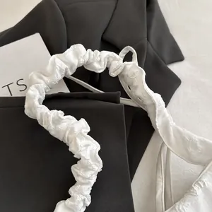 Detalle de cerca del elegante asa blanca fruncida de un bolso de hombro floral