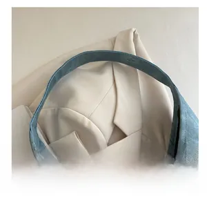 Close-up of wide denim shoulder strap with neat stitching on a blue tote bag