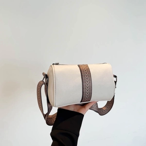 Chic off-white barrel bag with chevron wide strap and premium pebble grain texture