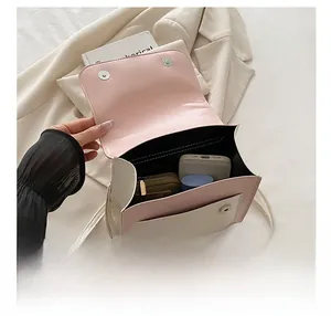 Pink and beige crossbody bag with magnetic flap showing interior storage capacity