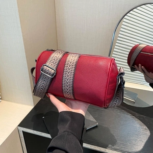 Red lychee grain leather cylinder bag with wide geometric strap and silver hardware