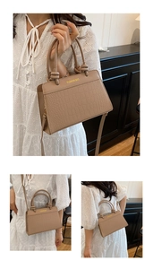 Detail of brown croc-effect leather handbag with knotted handle and fashion gold logo