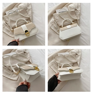 Detail view of white leather and beige woven patchwork bag with gold D-ring hardware
