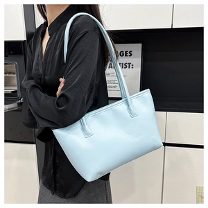 Close-up of light blue PU leather tote bag worn on shoulder for daily commute style