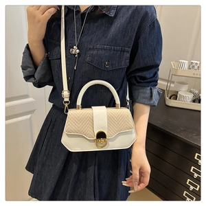 Detail of white leather and straw woven crossbody bag with gold metal buckle closure