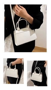 Detail of cream white faux leather bag with crocodile texture and twisted knot handle