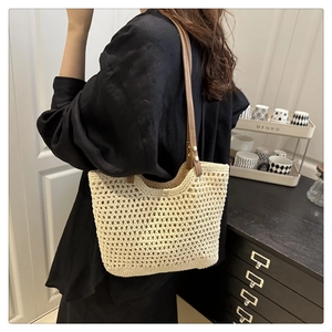 Détail du sac cabas en crochet beige avec anses en cuir marron et motif tissé