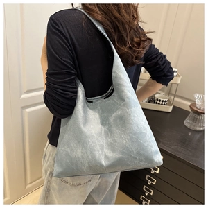 Detail of blue faux suede tote bag with wide strap showing material texture and size