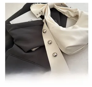 Close-up of the milk white PU leather handbag featuring a large bow and metallic rivets