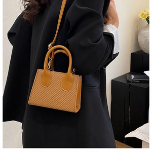 Détail du mini sac carré en paille avec poignée en cuir et bandoulière réglable