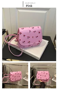Detail of pink saddle bag featuring cherry print, magnetic flap and adjustable strap