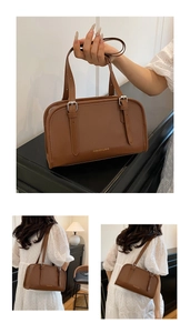 Detail of brown leather handbag with gold logo and adjustable shoulder straps