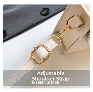 Detail of adjustable white leather shoulder strap with gold-plated metal hardware and hooks