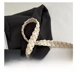 Gros plan sur la poignée tressée en cuir beige du sac cabas, détails de texture
