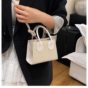 Dettaglio mini borsa bianca a trama intrecciata con tracolla regolabile per estate