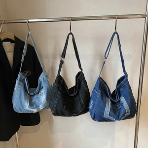 Three oversized denim tote bags in light blue, dark blue and black with frayed edges
