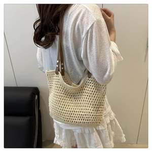 Détail du sac cabas en maille crochetée beige avec anses en cuir marron et rivets dorés