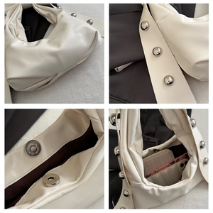 Detail view of cream pleated shoulder bag with silver studs and magnetic snap closure