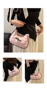 Detailed view of pink seersucker underarm bag with black bows and heart pendant