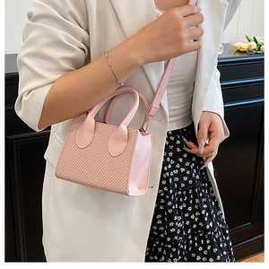 Dettagli della mini borsa rosa indossata su un abito a fiori con trama a rilievo