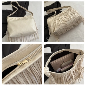 Détail du sac à franges blanc crème avec bandoulière tressée et fermeture éclair dorée