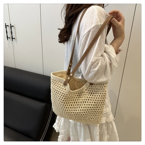 Détail du sac cabas en crochet évidé avec anses en cuir marron et rivets dorés