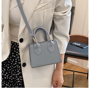 Dettaglio della borsa a tracolla grigio-blu con trama twill e hardware in metallo dorato