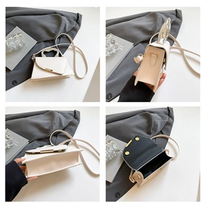 Detail view of cream acrylic handbag featuring silver metal handle and gold buckle