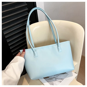 Detail of light blue minimalist tote bag in premium faux leather on a white chair