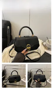 Detail of black PU leather box bag with woven texture and gold metal turn-lock closure