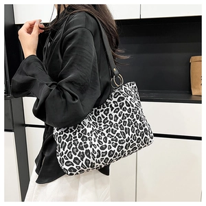 Close-up of black and white leopard print tote bag with metal ring and wide shoulder strap