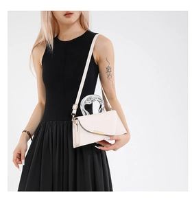 Detail of cream mini crossbody bag with gold buckle and translucent round handle