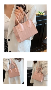 Dettaglio della borsa a tracolla intrecciata rosa chiaro con doppi manici e tracolla