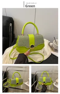 Detailed view of a green square bag with herringbone pattern flap and golden ring lock