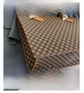 Detail view of vintage checkered tote bag with leather handles and decorative silk scarf