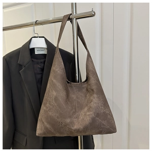 Detail of dark brown tote bag with vintage texture and vertical stitching detail