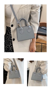 Dettaglio della trama intrecciata e degli inserti dorati su una mini borsa blu