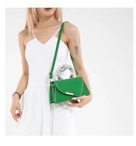 Detailed view of green crossbody bag with unique silver handle and gold metal trim