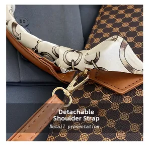 Detail of the golden metal buckle and printed silk scarf handle on brown leather bag