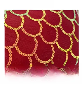 Détail du tissu en maille rouge avec des paillettes dorées sur un sac à main