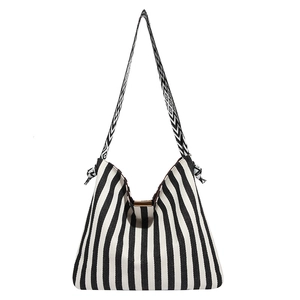 Striped canvas tote bag with black and white vertical patterns and geometric strap