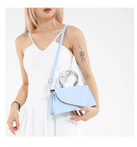 Detail of light blue geometric handbag with silver ring handle on a white background