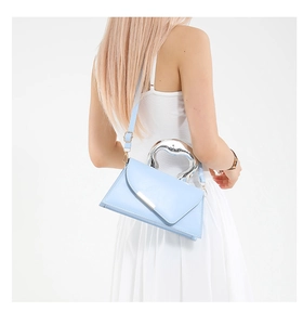 Close-up of stylish light blue structured handbag with golden trim and metallic handle