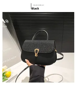 Detail of black crossbody bag with glitter flap and golden U-shaped rotating metal buckle