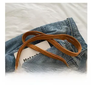 Detail view of smooth brown suede strap with fine stitching on a casual shoulder bag