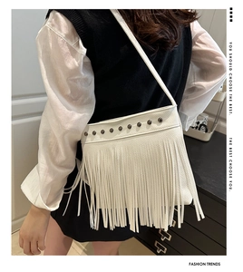 Détail du sac bandoulière en cuir blanc avec clous métalliques et longues franges